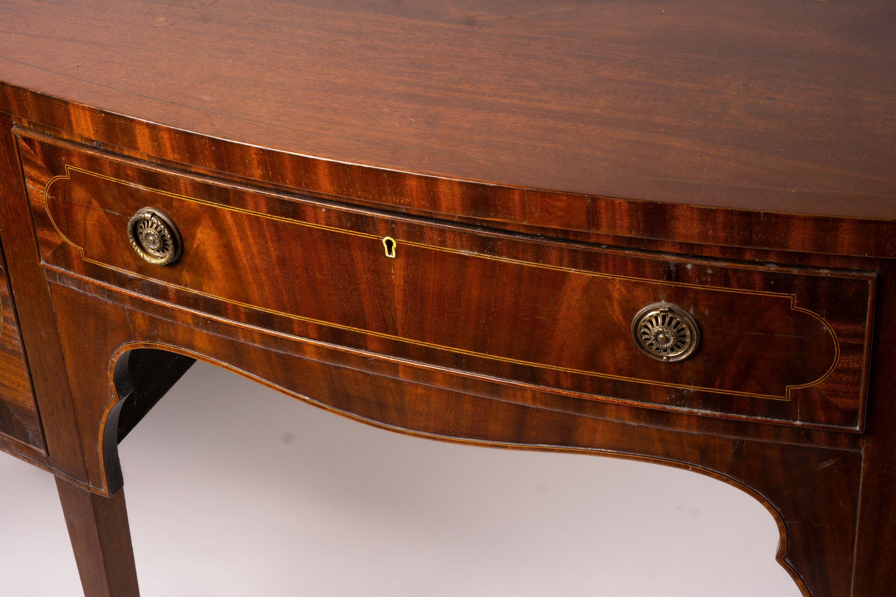 A George III style mahogany serpentine sideboard on square tapered legs, width 184cm, depth 63cm, height 93 cm